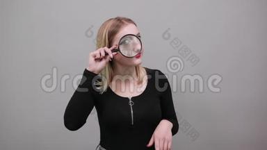 手里拿着放大镜的滑稽女人用放大镜来看